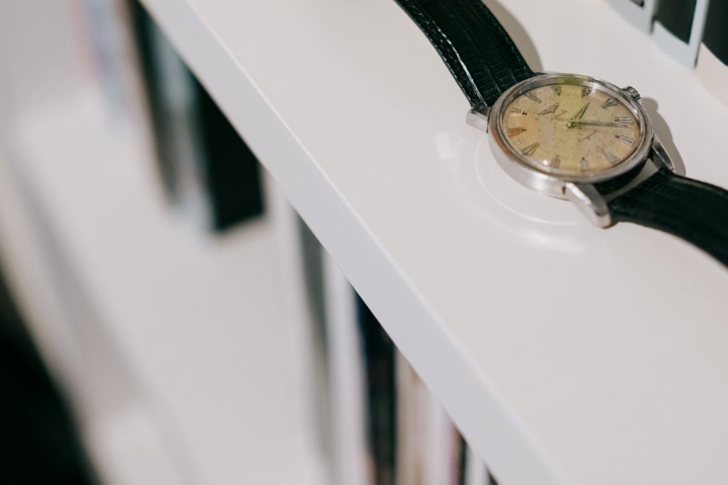 A watch on a bookcase.